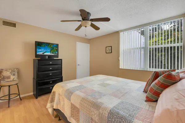 a bedroom with a bed a dresser and a painting