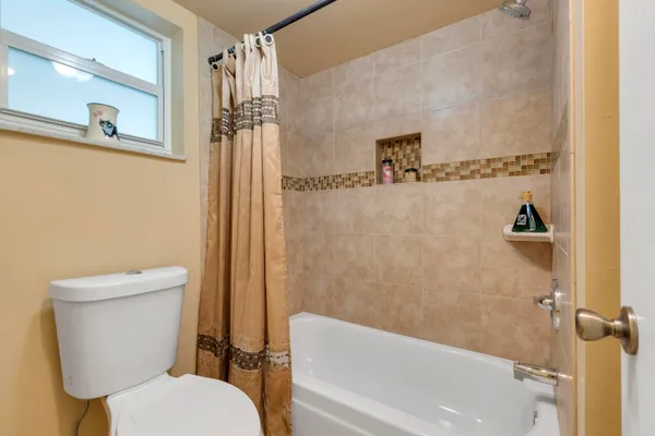 a white toilet sitting next to a bath tub