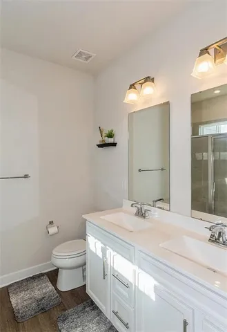 a bathroom with a sink a toilet and mirror
