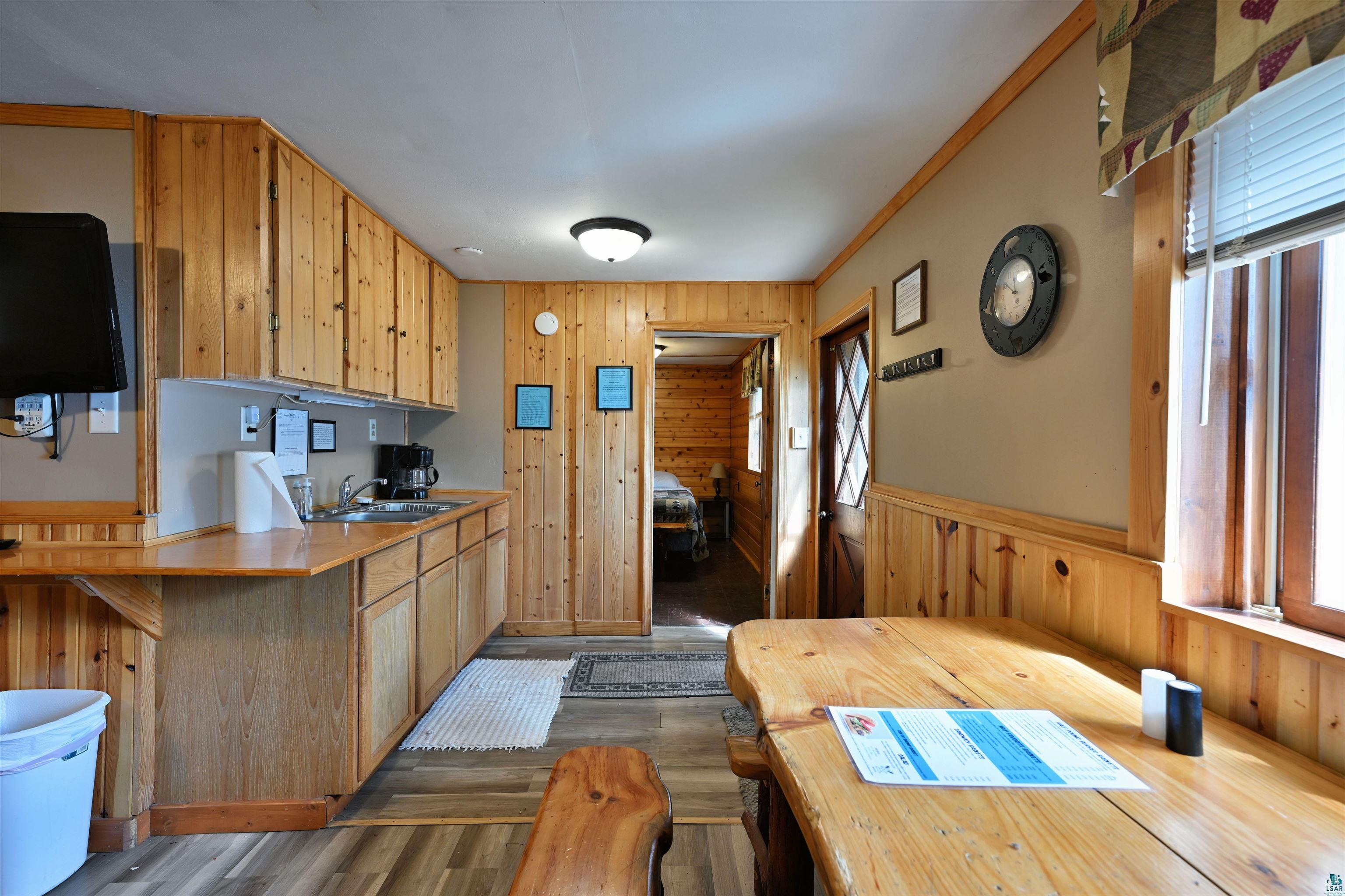 6833 View Point Lodge Road, Unit 13 Gordon, WI 54838 - Photo 19 of 32 Kitchen featuring wood walls, light countertops, dark wood-style floors, a peninsula, and light wood finish cabinetry