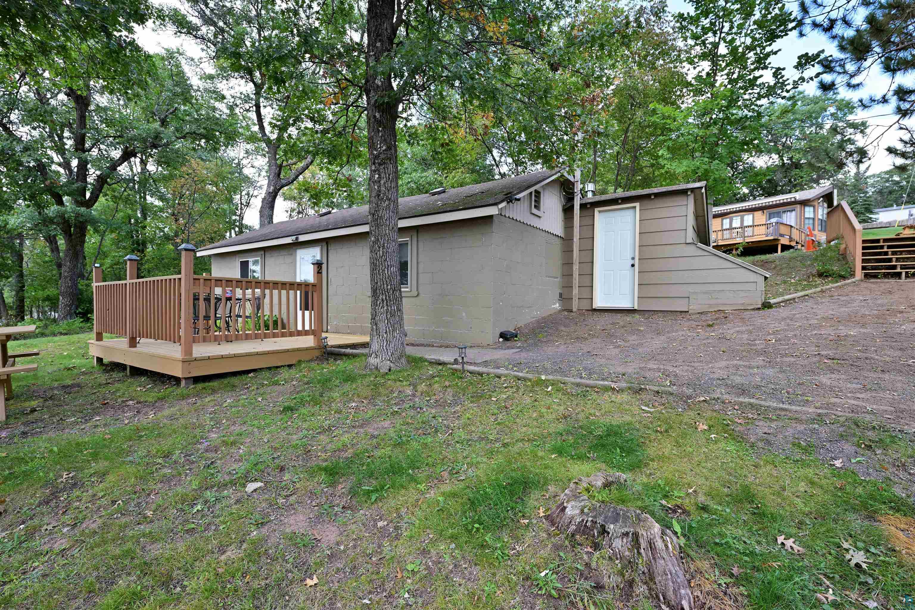 6833 View Point Lodge Road, Unit 13 Gordon, WI 54838 - Photo 2 of 32 Rear view of property featuring concrete block siding, a wooden deck, and view of scattered trees