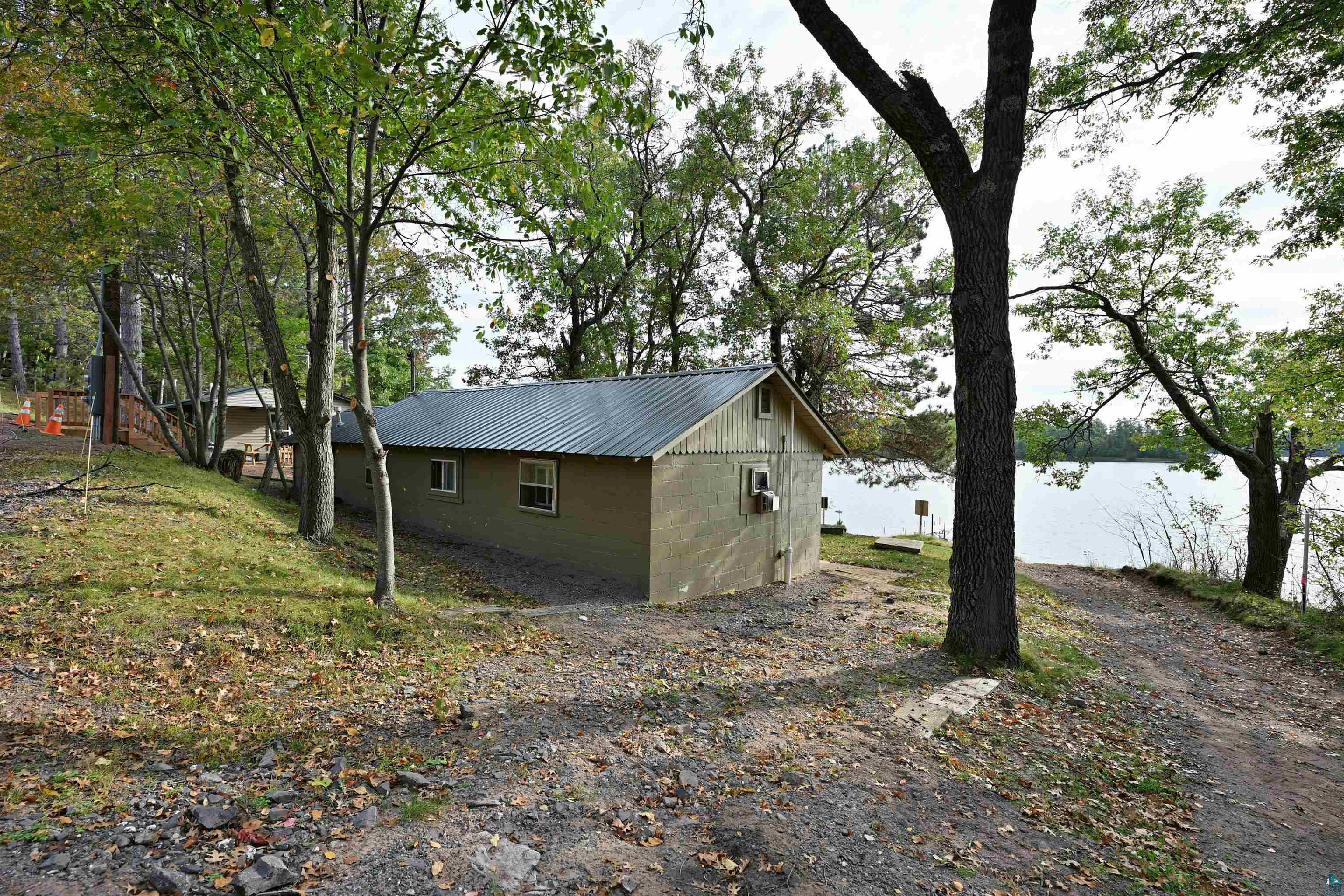 6833 View Point Lodge Road, Unit 13 Gordon, WI 54838 - Photo 32 of 32 View of side of property featuring concrete block siding, a metal roof, and a water view