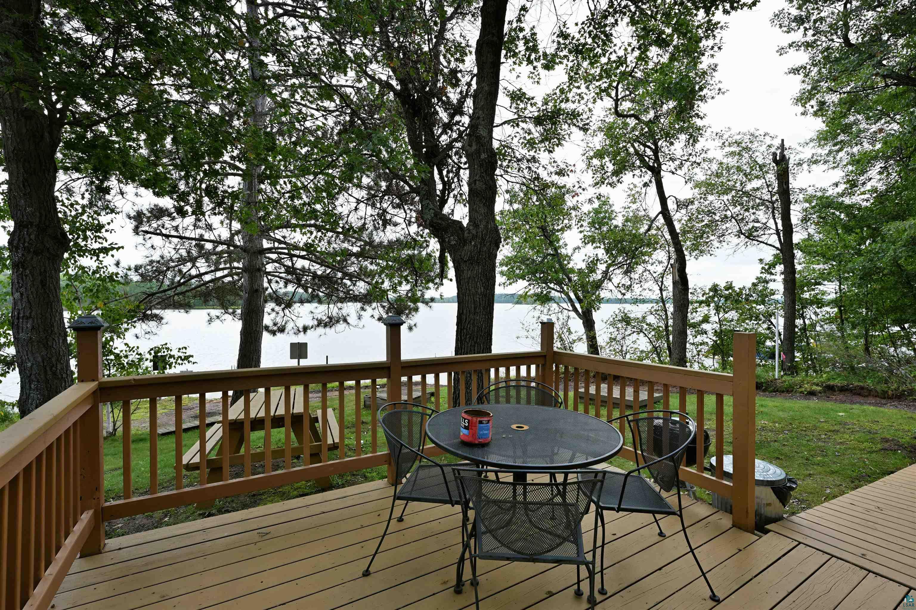 6833 View Point Lodge Road, Unit 13 Gordon, WI 54838 - Photo 8 of 32 Deck with outdoor dining space, a water view, and a lawn