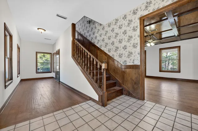 a view of an empty room with glass door and wooden floor