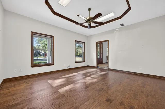 a view of a livingroom with wooden floor and a ceiling fan