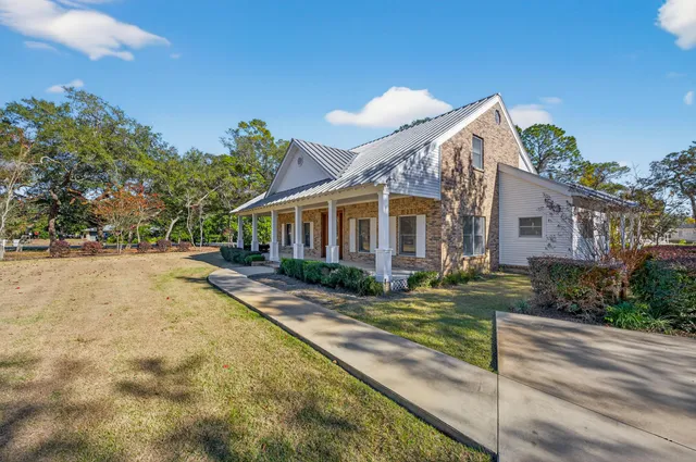 a front view of house with yard and trees in the background