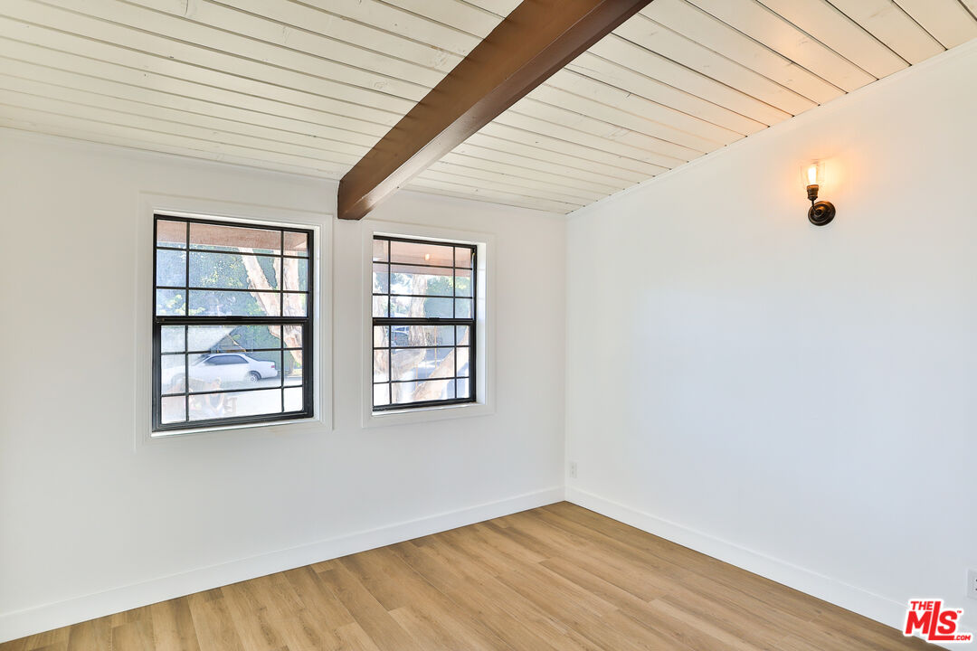 20341 Enadia Way Winnetka, CA 91306 - Photo 11 of 23 an empty room with wooden floor and windows