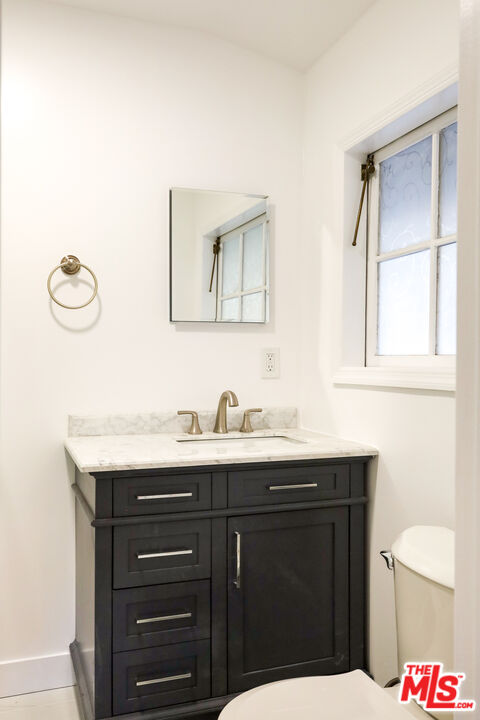 20341 Enadia Way Winnetka, CA 91306 - Photo 18 of 23 a bathroom with a granite countertop sink and a mirror