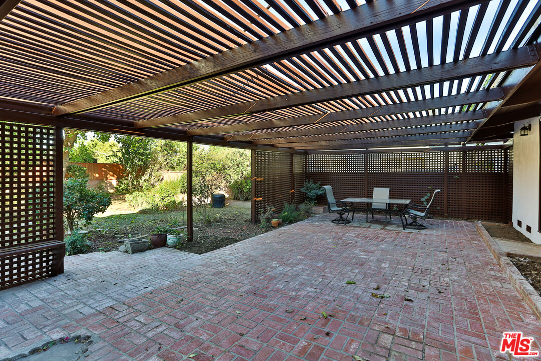 20341 Enadia Way Winnetka, CA 91306 - Photo 20 of 23 a view of a backyard with sitting area furniture and iron fence