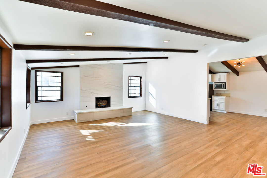20341 Enadia Way Winnetka, CA 91306 - Photo 3 of 23 a view of an empty room with wooden floor and a window