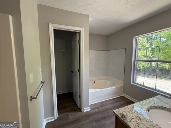a bathroom with a tub a sink and a window