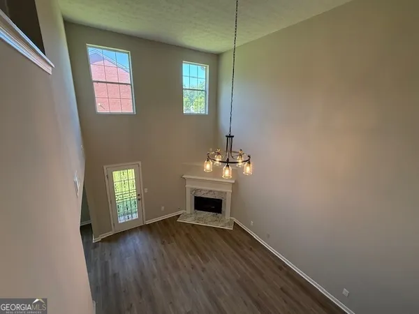 a view of an empty room with window and fire place