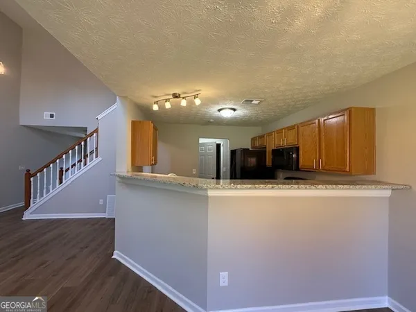 a view of kitchen with stainless steel appliances wooden floor