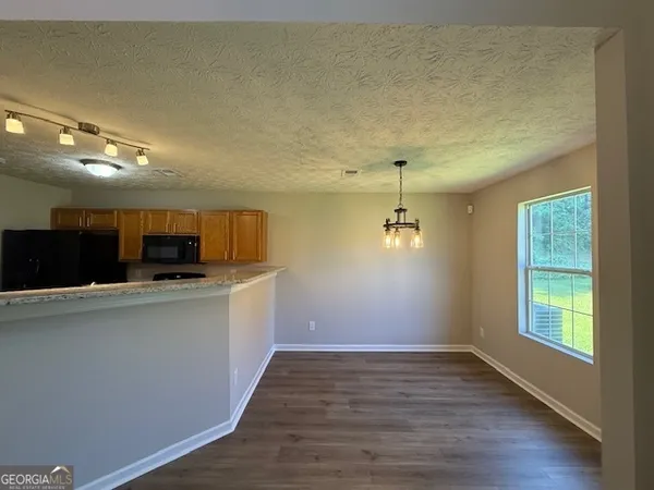 a view of a kitchen with a sink wooden cabinets and a window