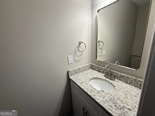 a bathroom with a granite countertop sink and a mirror