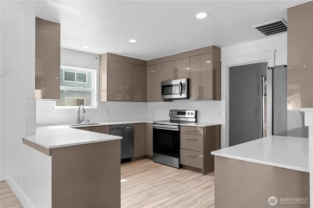 a kitchen with stainless steel appliances granite countertop a sink stove and refrigerator