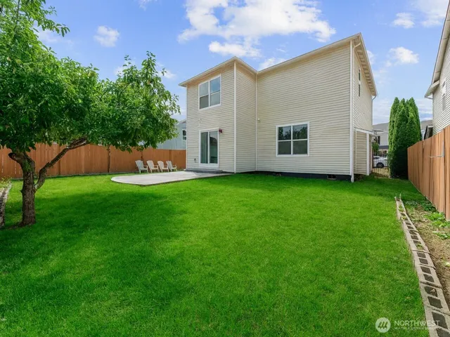 a view of a house with a backyard and a tree