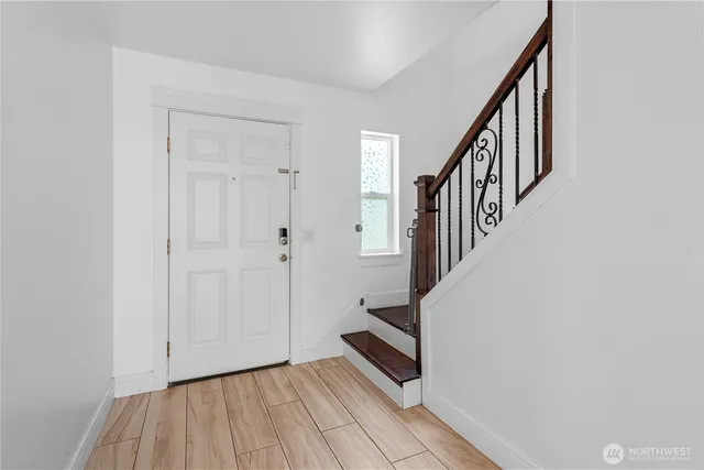 a view of a hallway with wooden floor and staircase