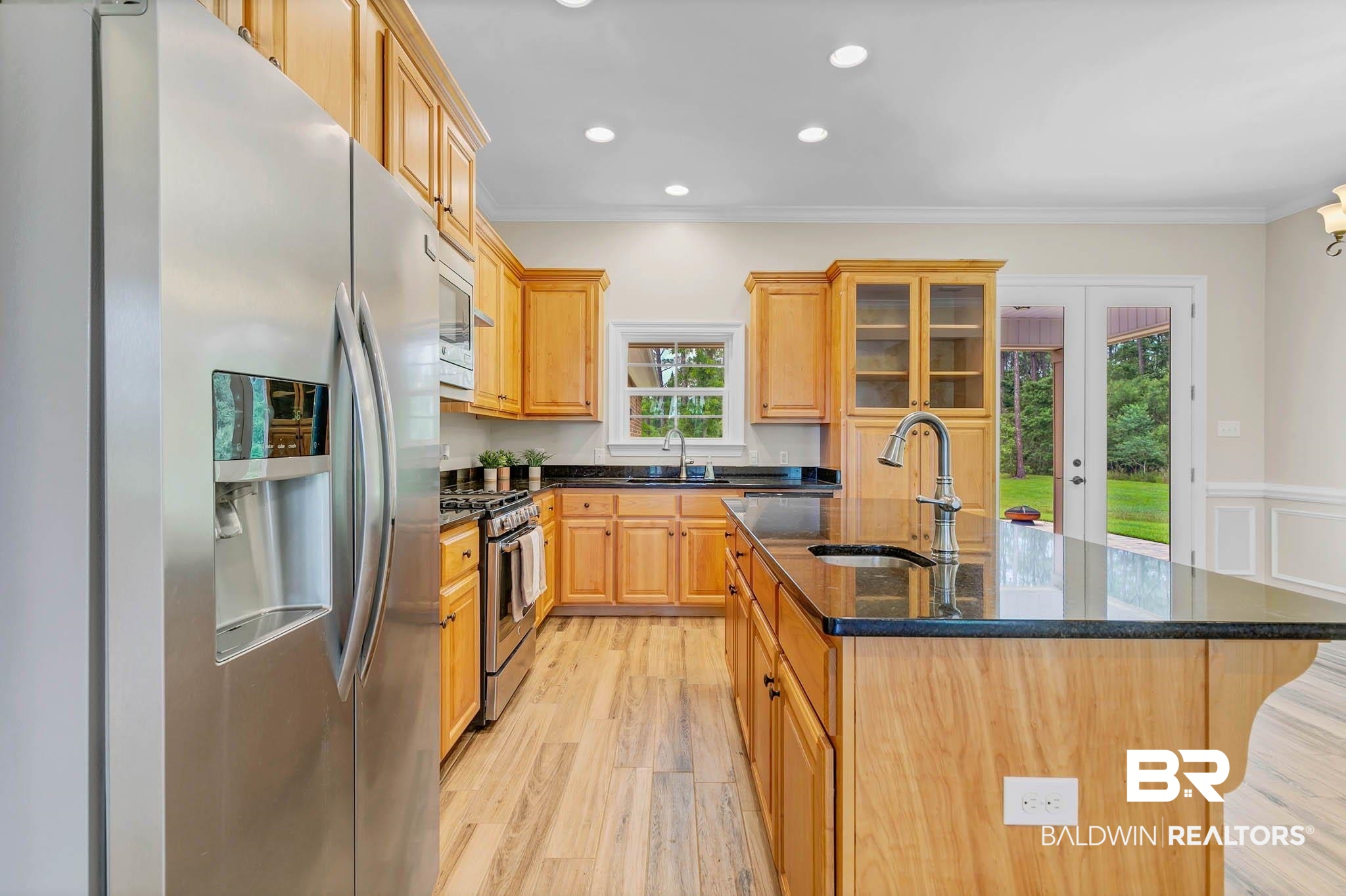 8145 Bay View Drive Foley, AL 36535 - Photo 20 of 81 Kitchen with appliances with stainless steel finishes, a kitchen island with sink, french doors, ornamental molding, and light wood-style floors