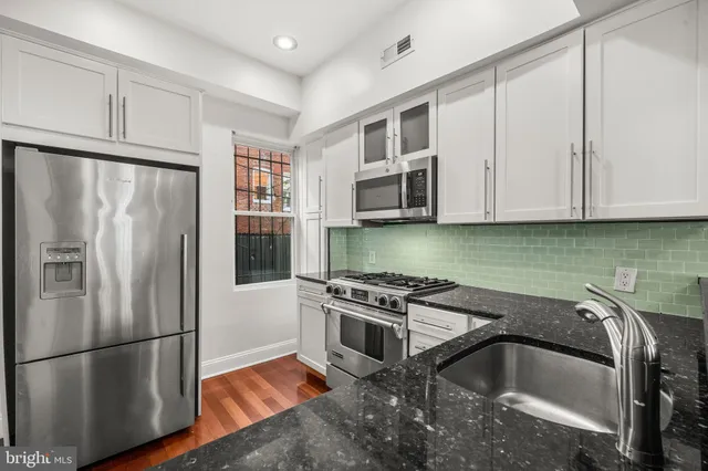 a kitchen with stainless steel appliances granite countertop a refrigerator sink and cabinets