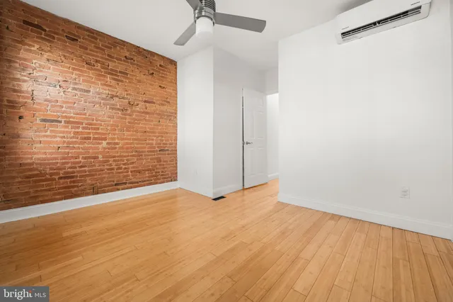 a view of an empty room with wooden floor