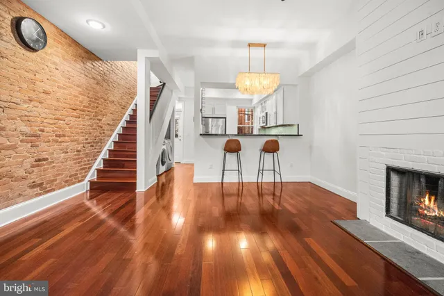 a view of main area with wooden floor fireplace and staircase