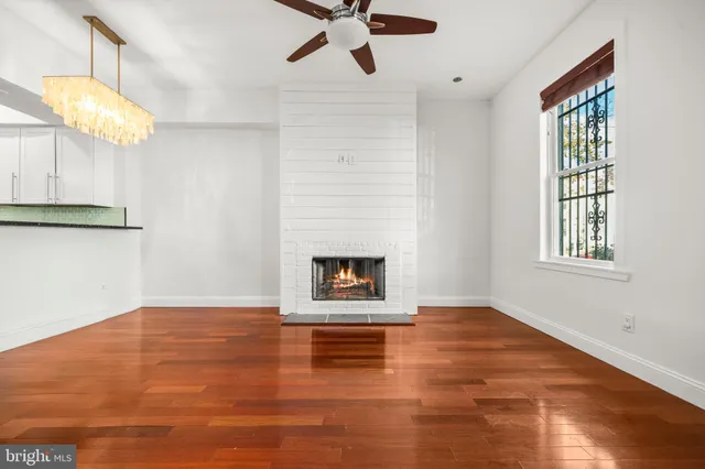 an empty room with windows and fireplace