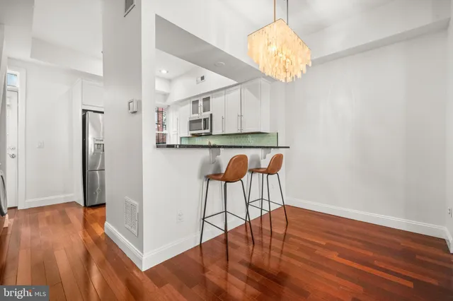 a view of dining room with wooden floor and chandelier