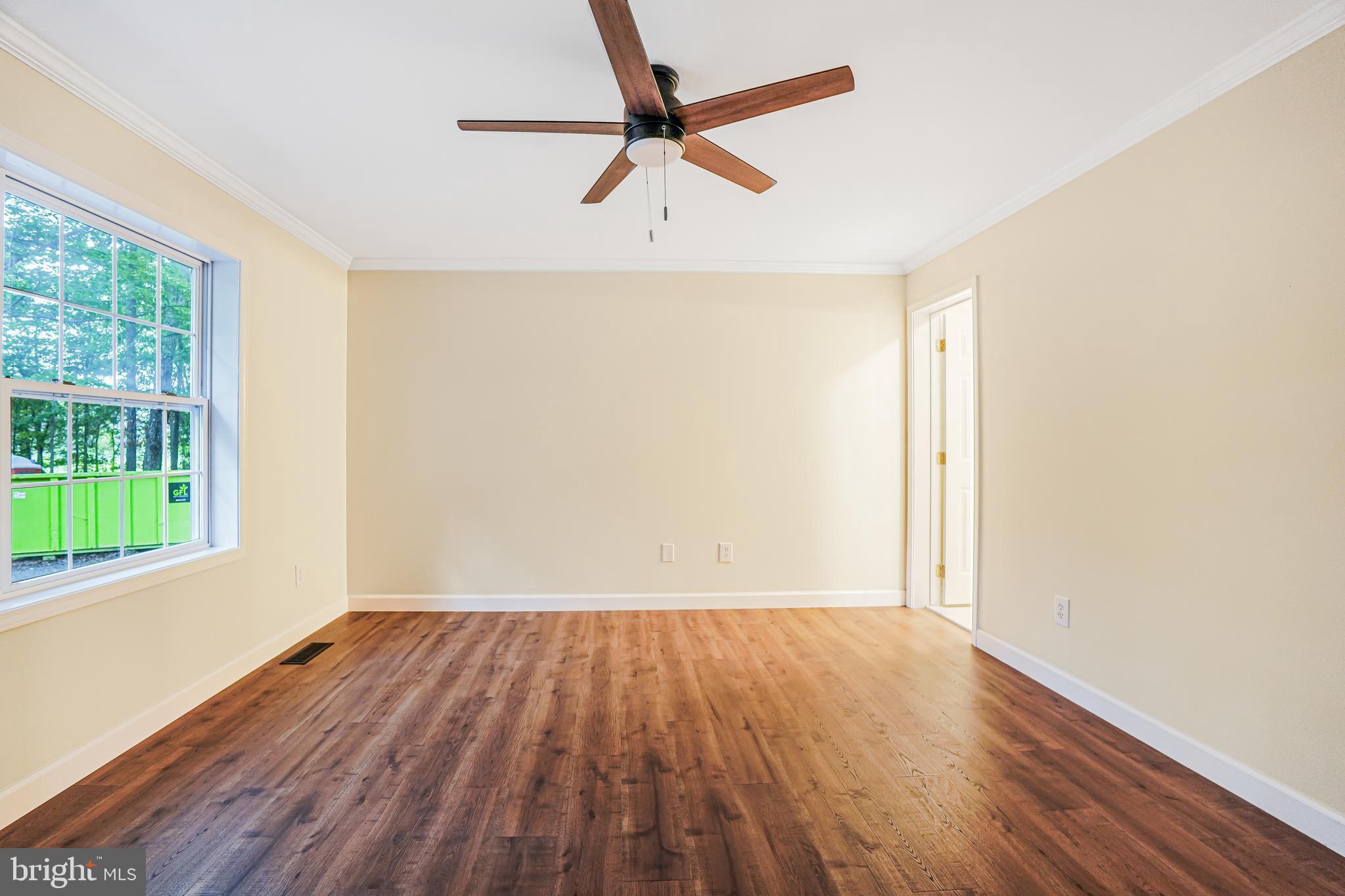 767 Loving Road Zion Crossroads, VA 22942 - Photo 19 of 33 an empty room with wooden floor fan and windows