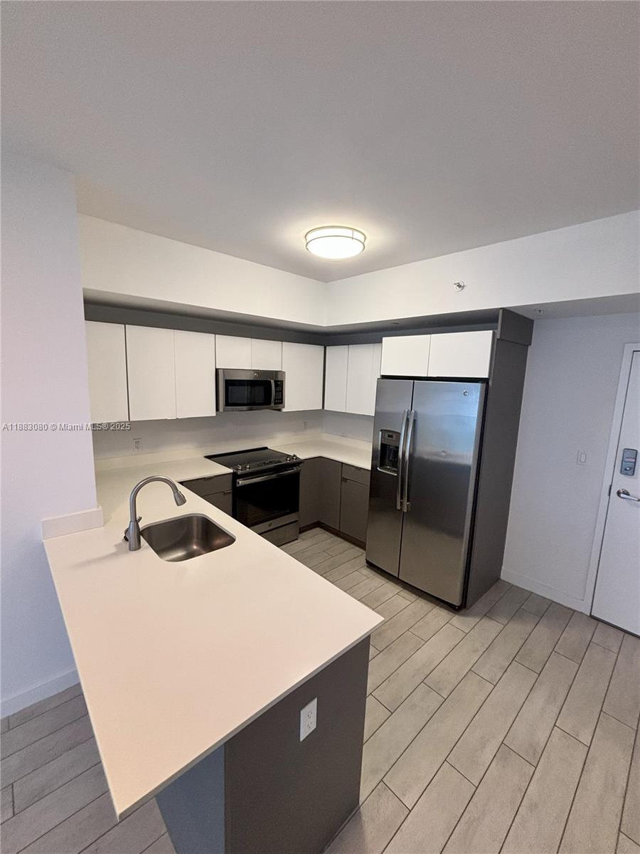 321 Northeast 26th Street, Unit 710 Miami, FL 33137 - Photo 13 of 21 a kitchen that has a sink and a refrigerator