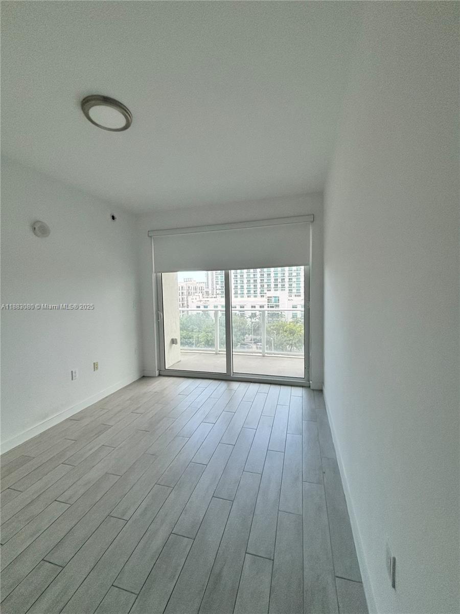 321 Northeast 26th Street, Unit 710 Miami, FL 33137 - Photo 17 of 21 wooden floor in an empty room with a window