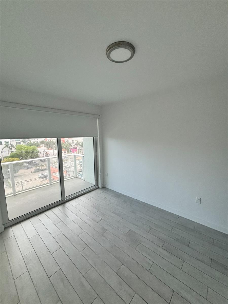 321 Northeast 26th Street, Unit 710 Miami, FL 33137 - Photo 18 of 21 a view of empty room with wooden floor and fan