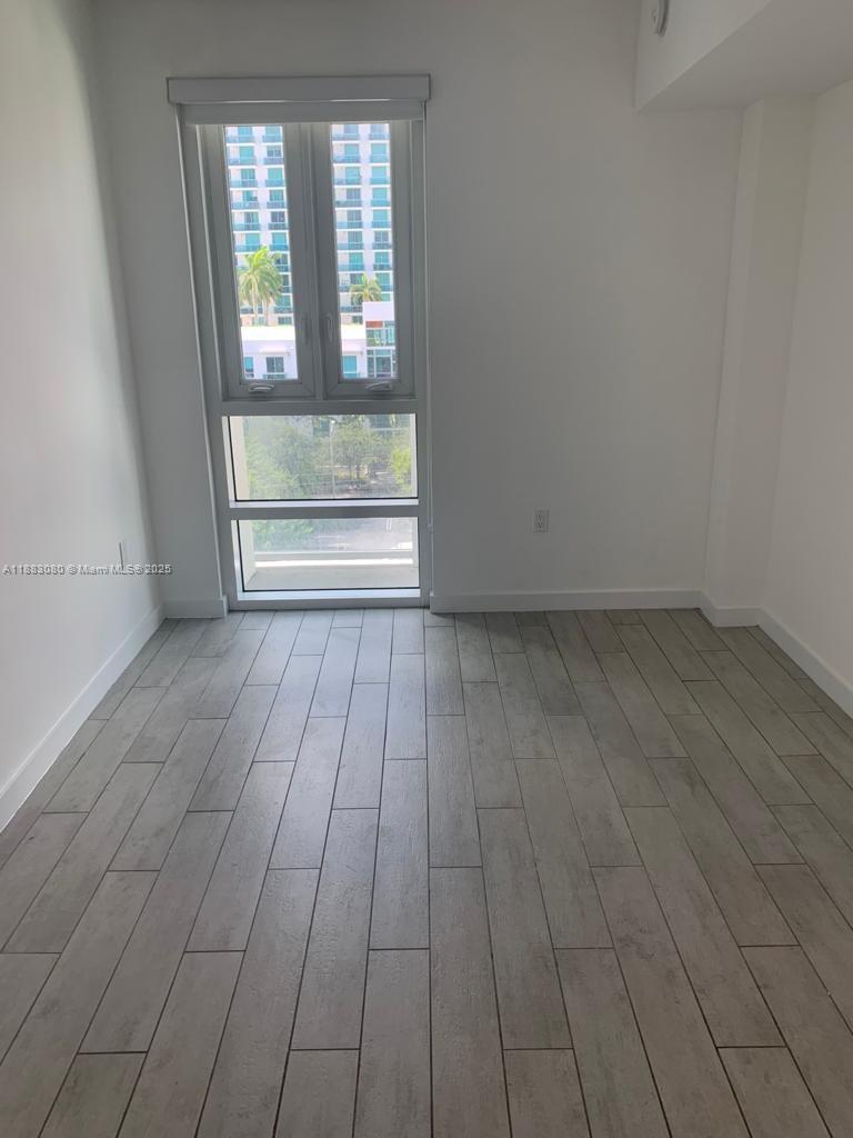 321 Northeast 26th Street, Unit 710 Miami, FL 33137 - Photo 19 of 21 an empty room with wooden floor and windows