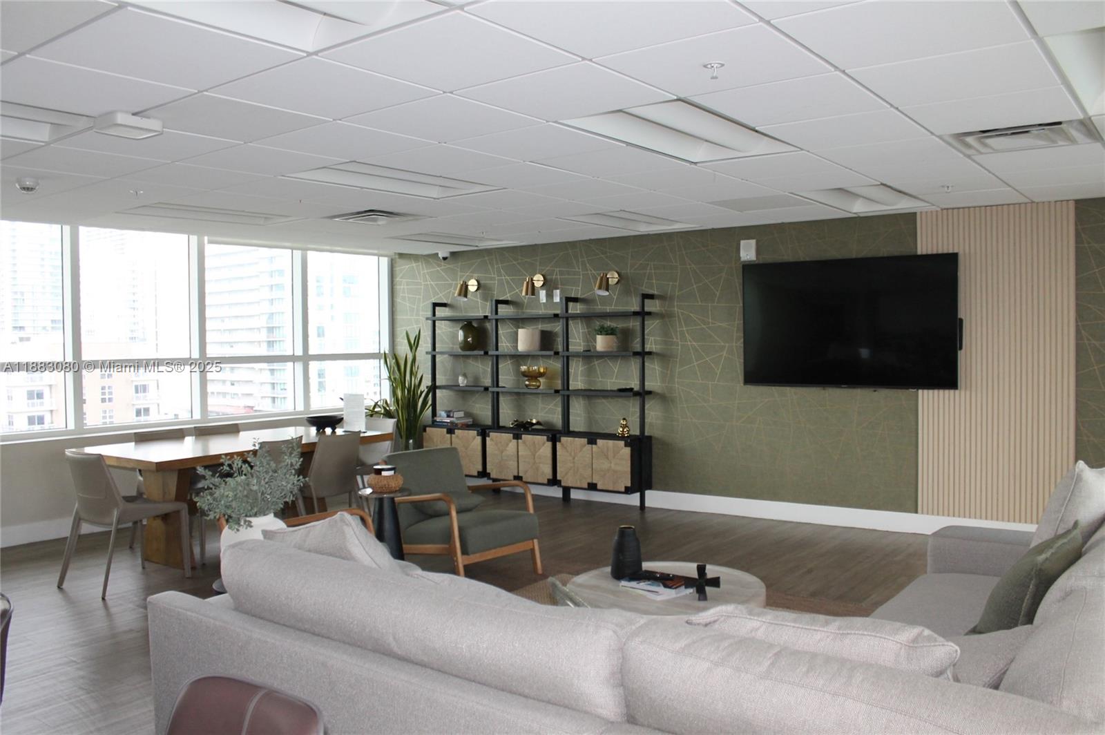 321 Northeast 26th Street, Unit 710 Miami, FL 33137 - Photo 9 of 21 a living room with furniture a flat screen tv and a floor to ceiling window