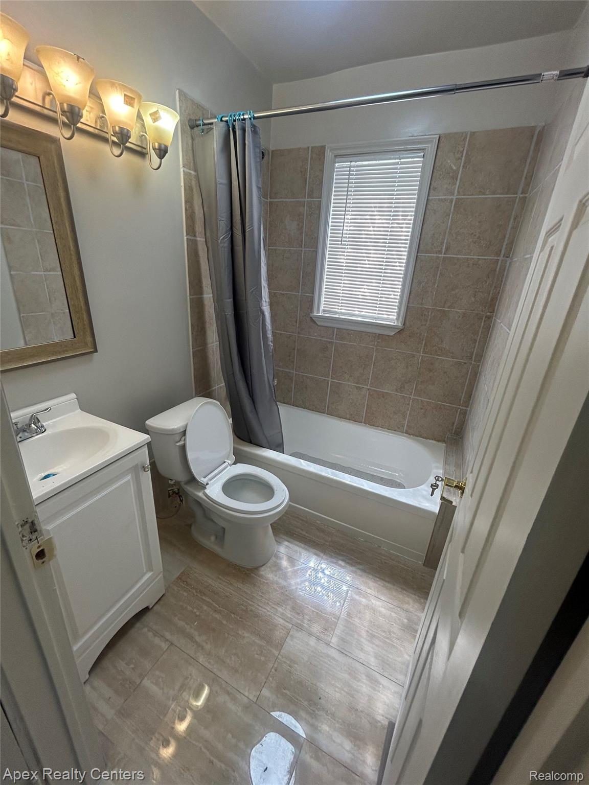 3158 Hickory Street Inkster, MI 48141 - Photo 13 of 15 Full bathroom featuring a white vanity with integrated sink, toilet, and a tub-shower combination with full-height tiled surround