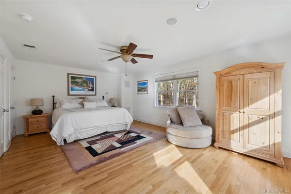 a spacious bedroom with a bed a couch and a large window