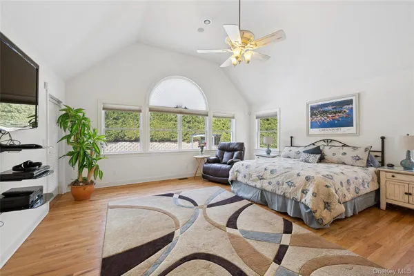 a spacious bedroom with a large bed and a chandelier
