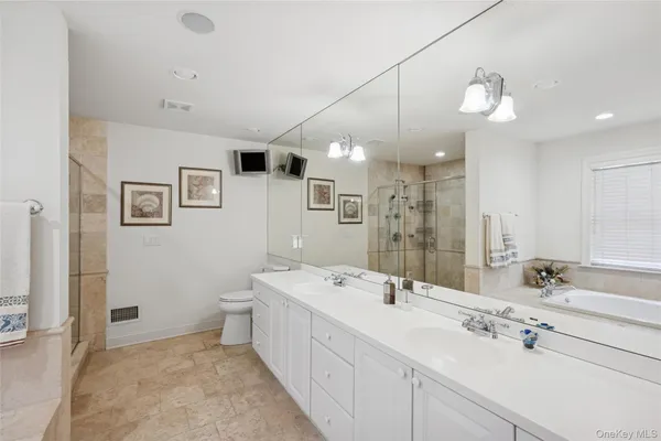 a spacious bathroom with a double vanity sink a mirror and a shower