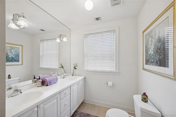 a bathroom with 2 sink tub and a mirror