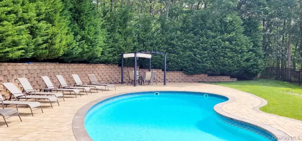 a swimming pool with outdoor seating and yard