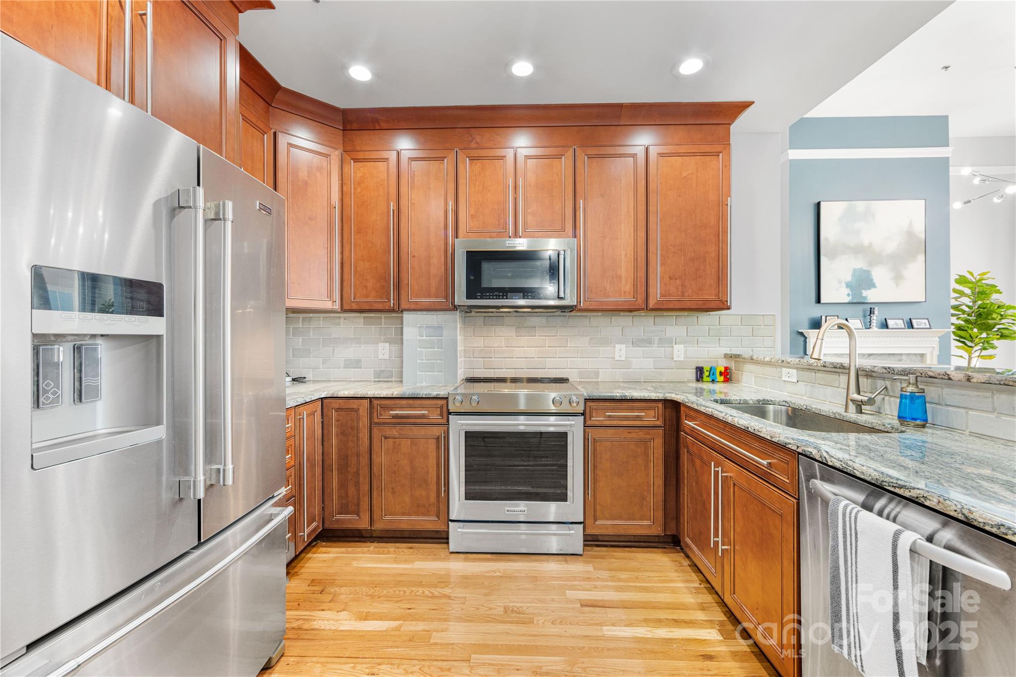 127 North Tryon Street, Unit 511 Charlotte, NC 28246 - Photo 11 of 32 a kitchen with stainless steel appliances granite countertop a stove a sink and a refrigerator