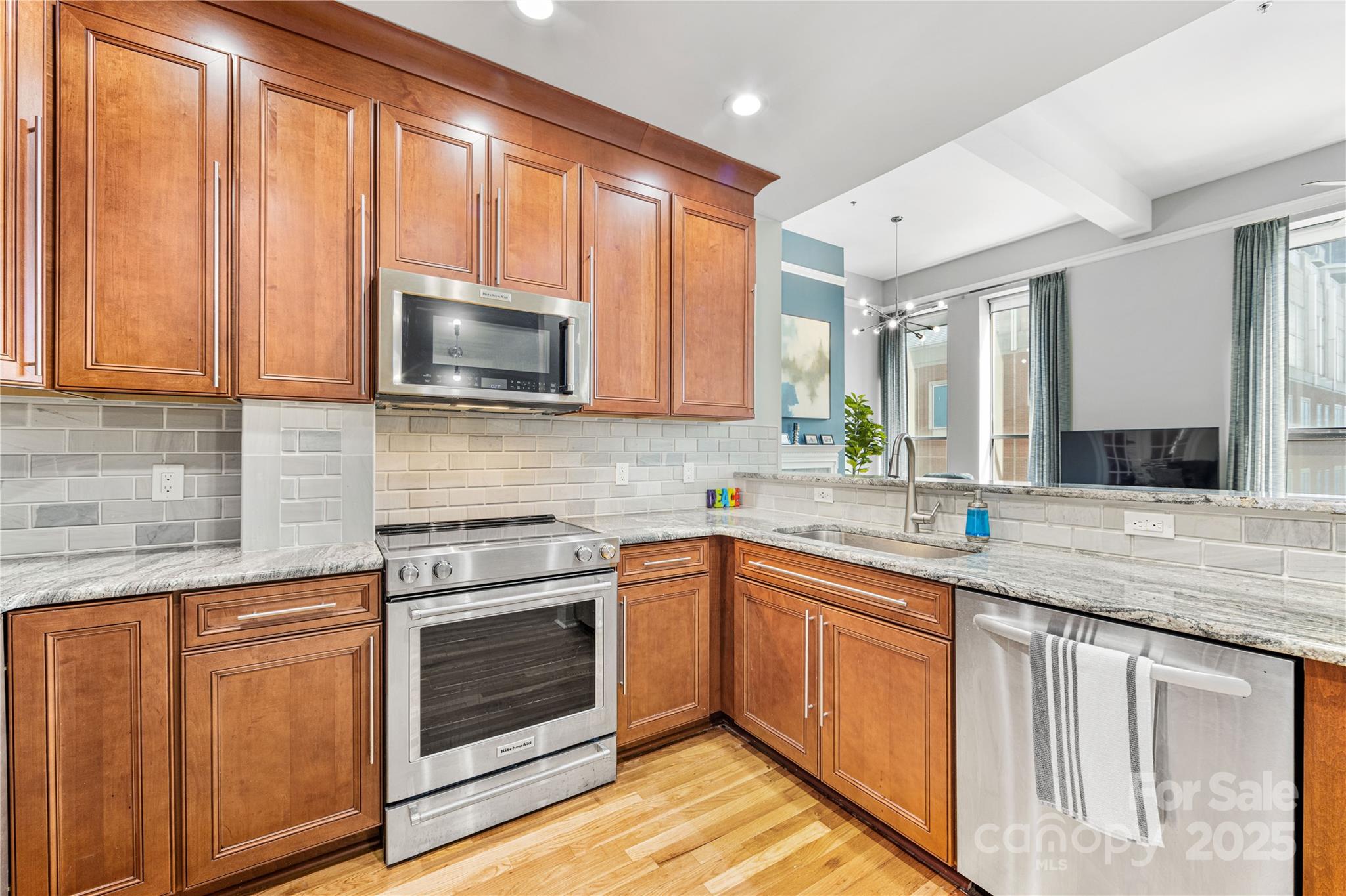 127 North Tryon Street, Unit 511 Charlotte, NC 28246 - Photo 12 of 32 a kitchen with granite countertop cabinets stainless steel appliances and a sink