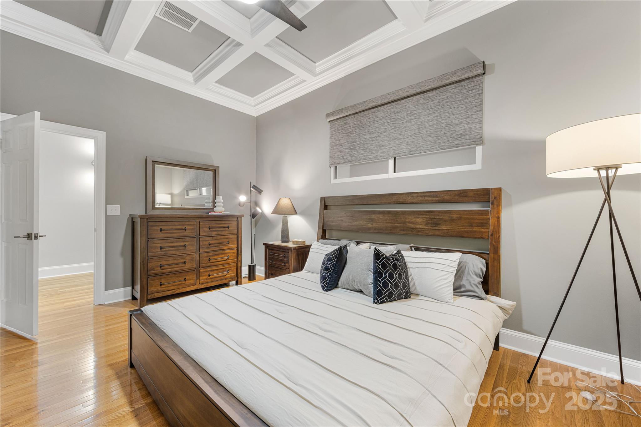 127 North Tryon Street, Unit 511 Charlotte, NC 28246 - Photo 17 of 32 a bedroom with a bed and wooden floor