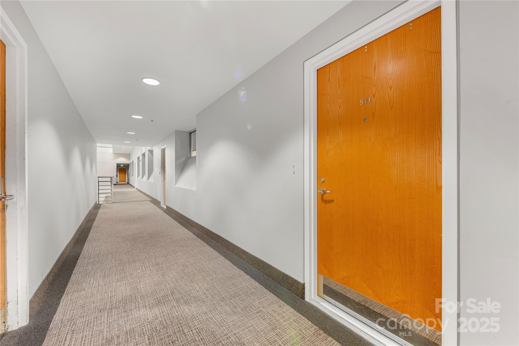 127 North Tryon Street, Unit 511 Charlotte, NC 28246 - Photo 4 of 32 a view of a hallway with windows