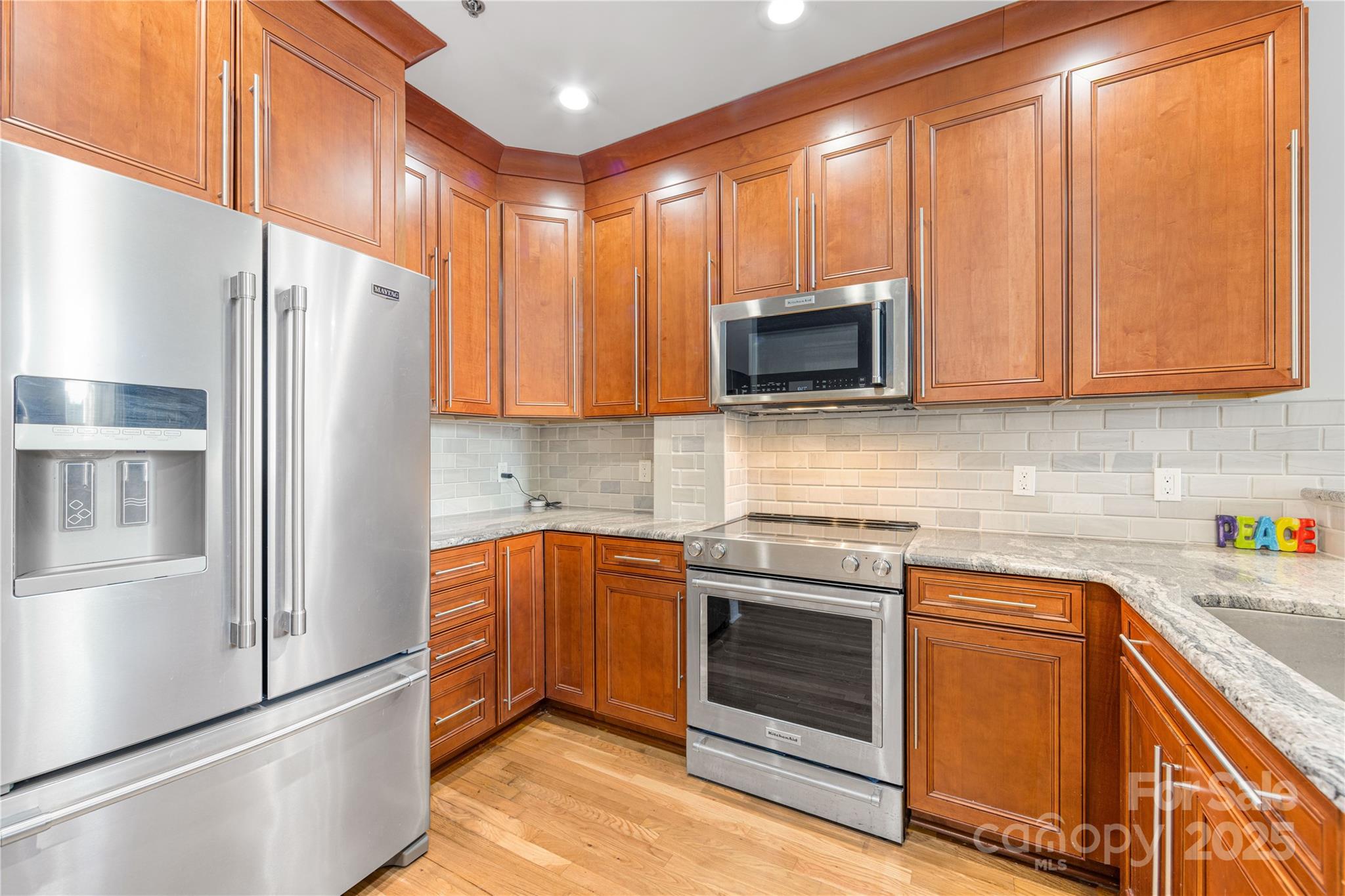 127 North Tryon Street, Unit 511 Charlotte, NC 28246 - Photo 10 of 32 a kitchen with stainless steel appliances granite countertop a refrigerator a stove a sink and a microwave