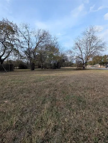 a view of a field with trees in the background