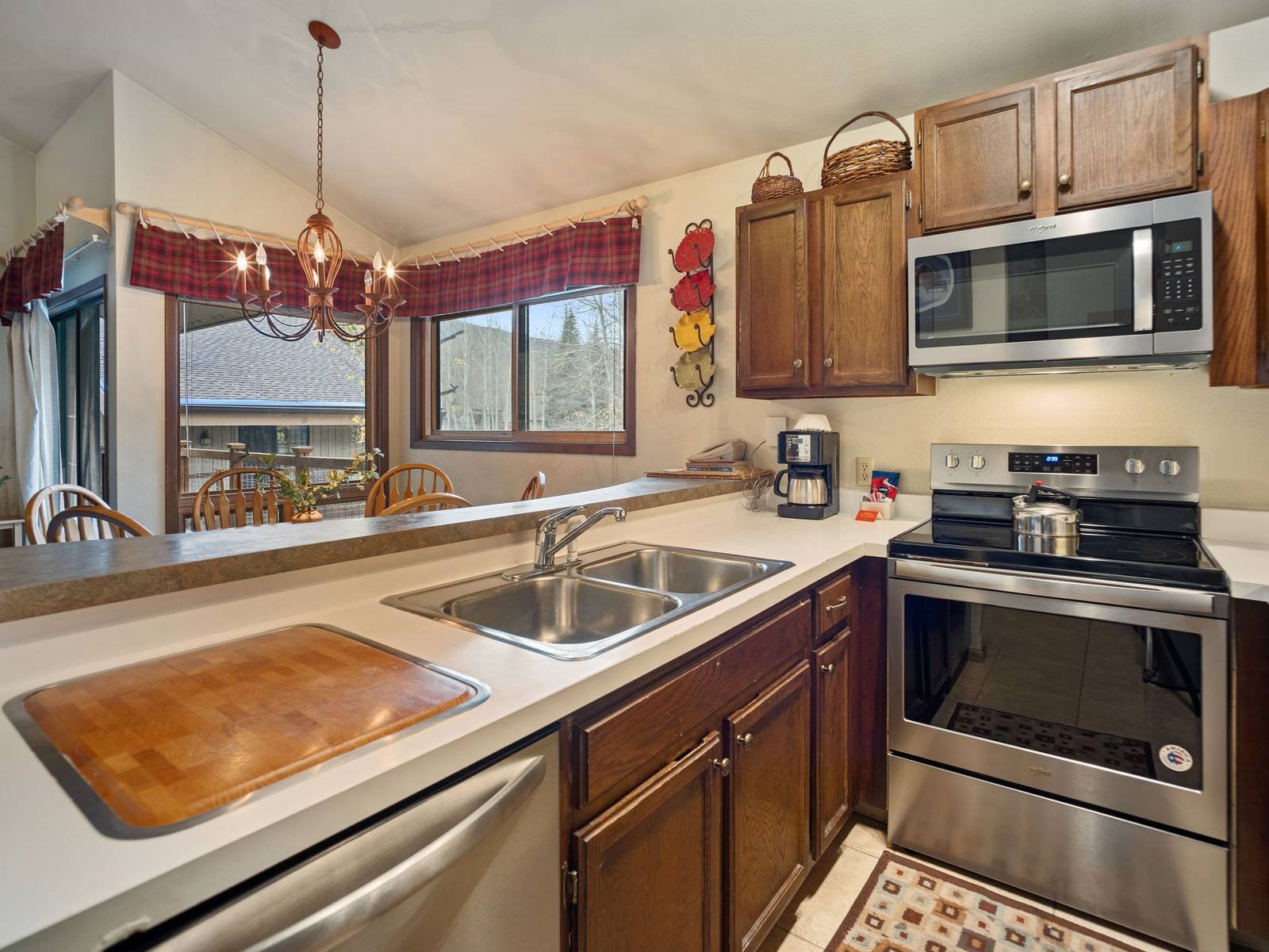 1937 Soda Ridge Road, Unit 1139 Keystone, CO 80435 - Photo 11 of 32 Kitchen featuring appliances with stainless steel finishes, sink, lofted ceiling, decorative light fixtures, and a notable chandelier