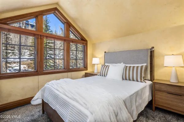 a bedroom with a bed and a large window