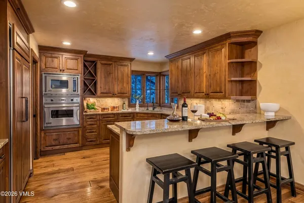 a kitchen with refrigerator a sink and chairs