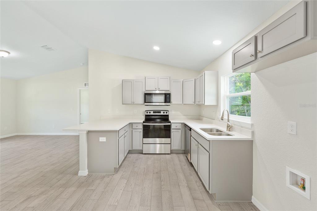 358 Locust Road Ocala, FL 34472 - Photo 18 of 48 a kitchen with stainless steel appliances a stove sink and microwave